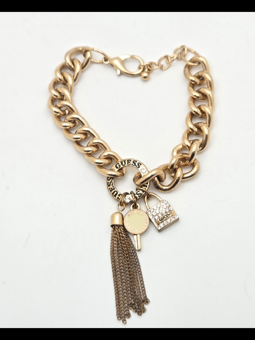GUESS Gold Tone Chunky Curb Chain Bracelet with Tassel & Lock Charms